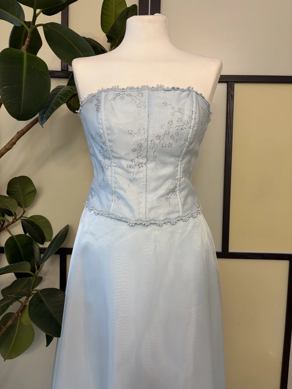 A blue dress with a wide skirt supported by a petticoat and a glitter-embellished bodice