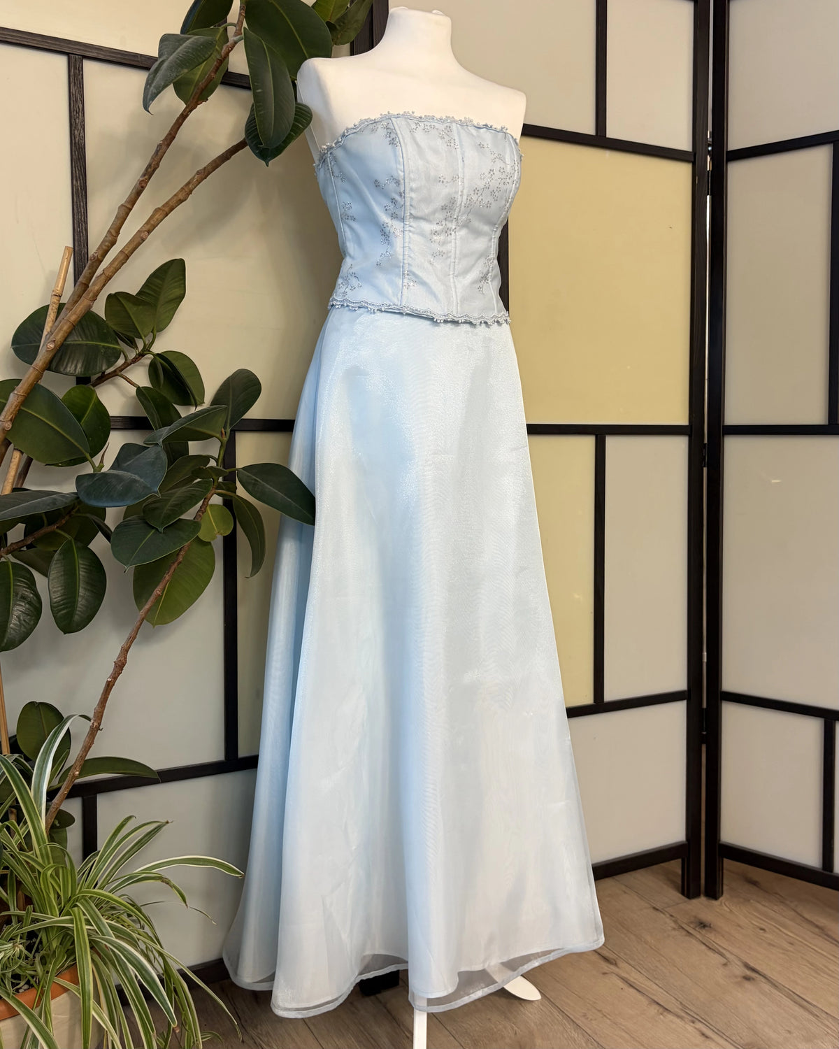 A blue dress with a wide skirt supported by a petticoat and a glitter-embellished bodice