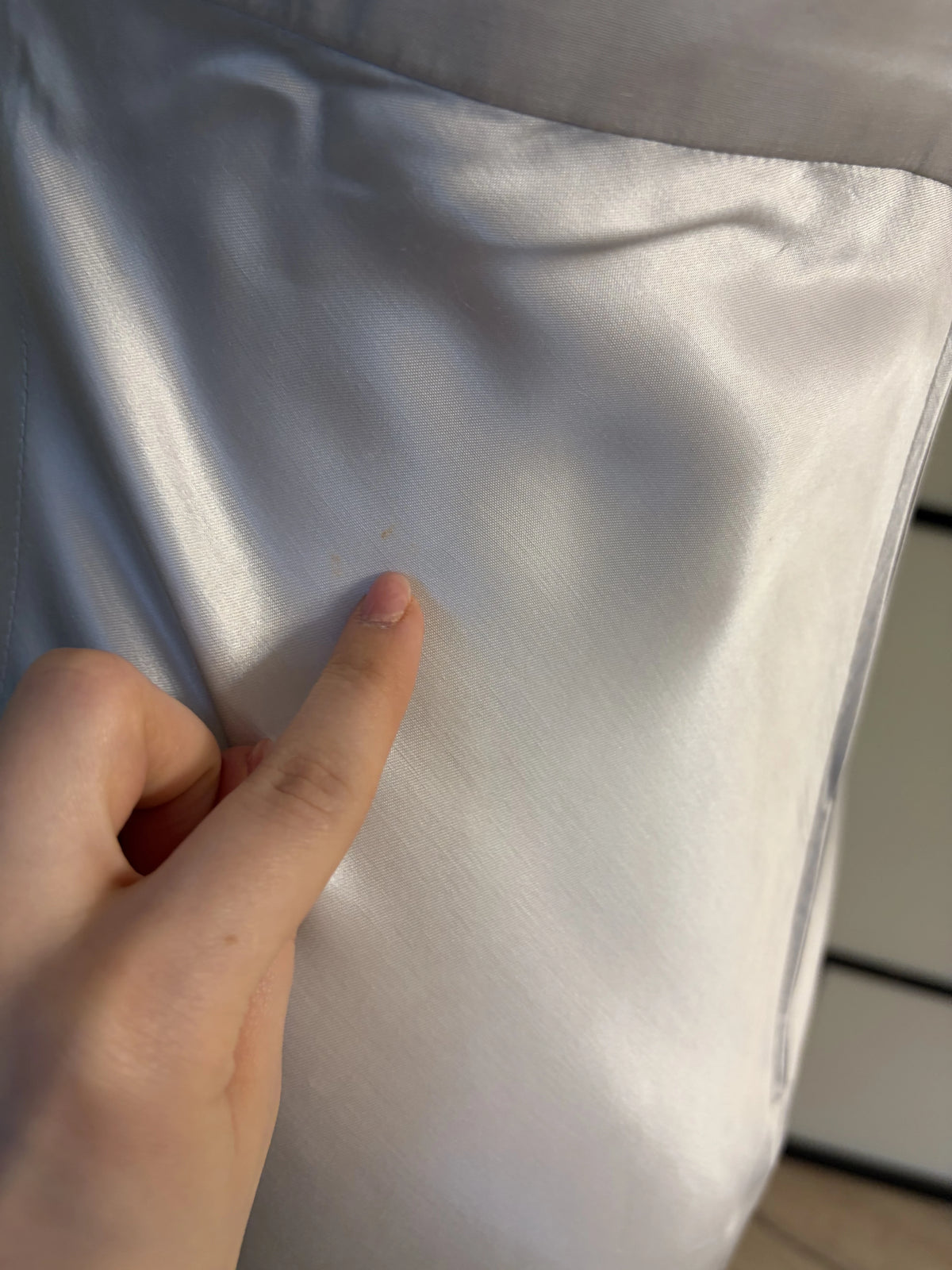 Biało-srebrzysta suknia z połyskującego materiału