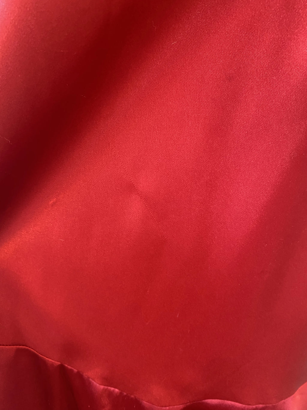 Czerwona suknia z koralikami wokół wycięcia na mostku